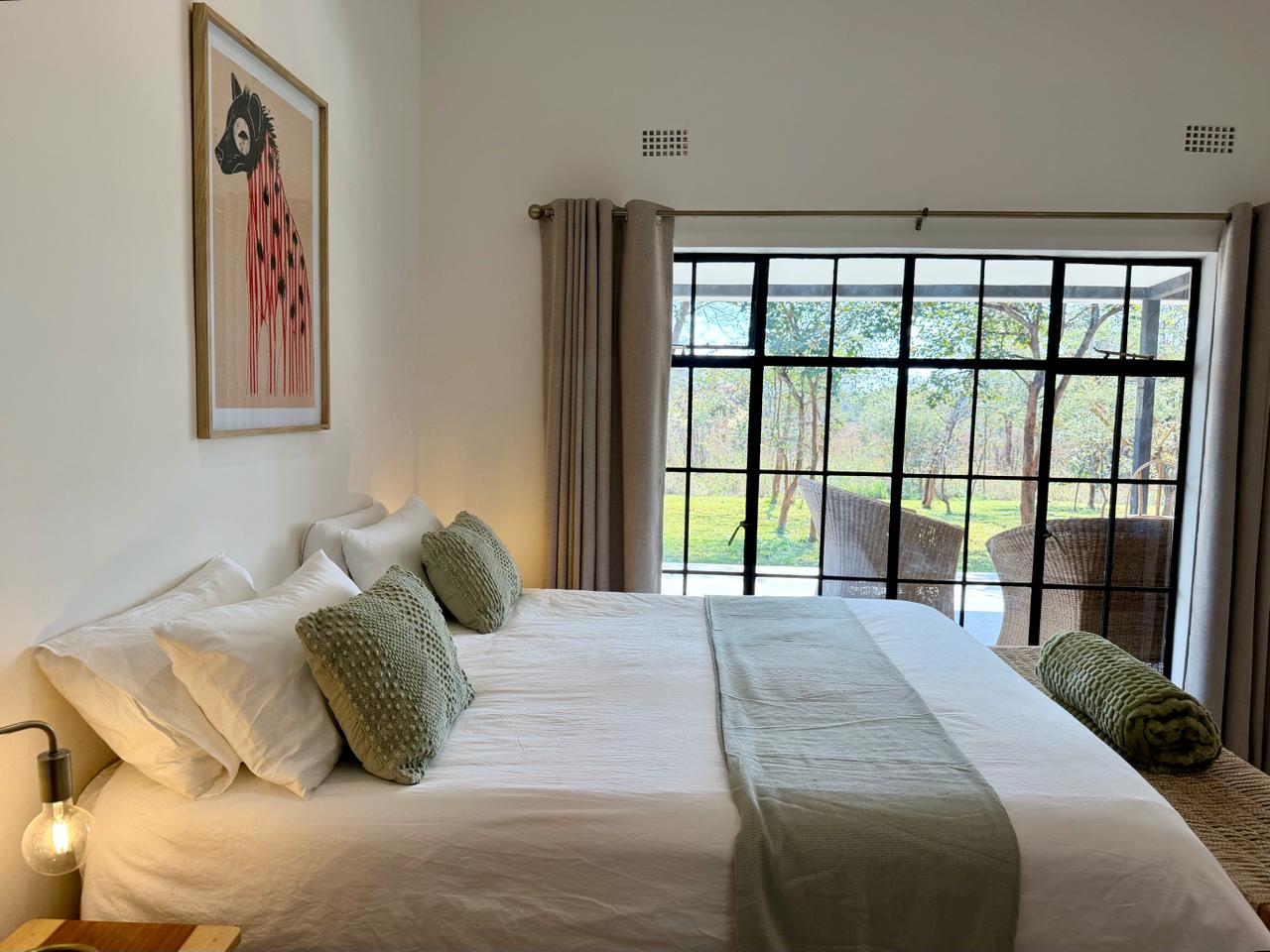 The double bedroom looking toward the garden through a black-framed window